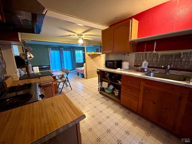 kitchen with decorative backsplash, ceiling fan, and sink