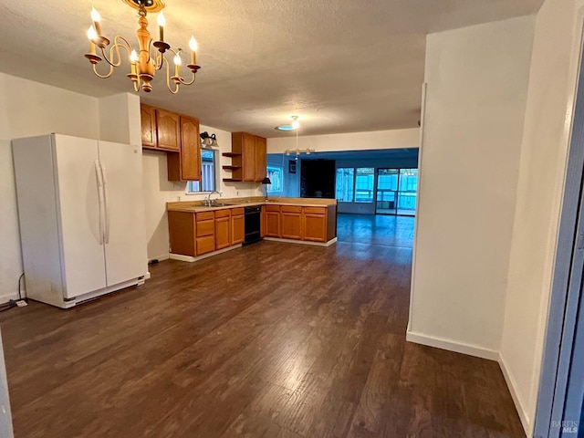 kitchen with kitchen peninsula, white fridge, dark hardwood / wood-style floors, sink, and a notable chandelier