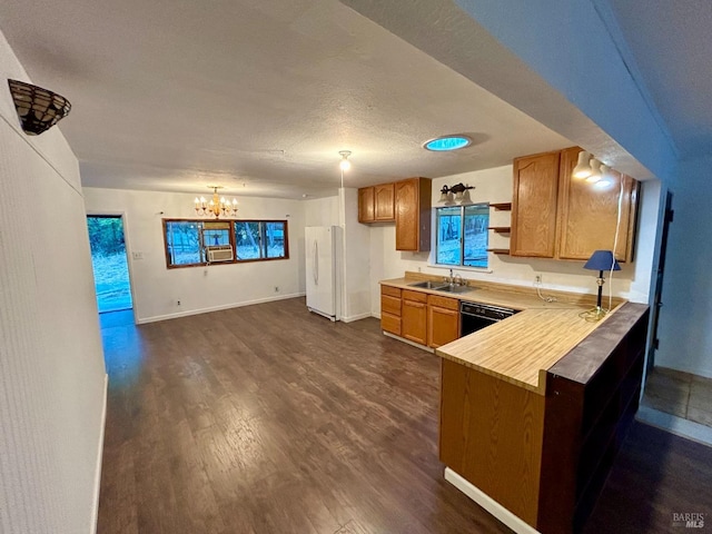 kitchen featuring kitchen peninsula, a textured ceiling, an inviting chandelier, white fridge, and dark hardwood / wood-style flooring