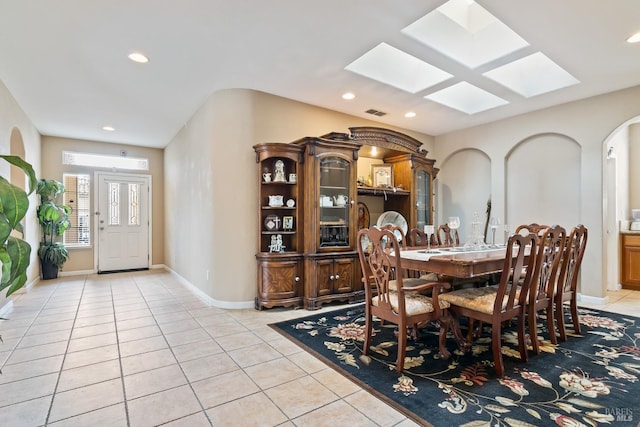 dining area featuring light tile patterned floors, a skylight, visible vents, baseboards, and recessed lighting