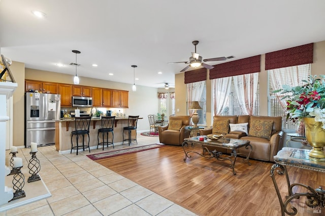 living area with light tile patterned floors, visible vents, baseboards, ceiling fan, and recessed lighting