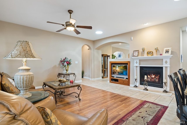 living area featuring ceiling fan, recessed lighting, baseboards, tile patterned floors, and a glass covered fireplace