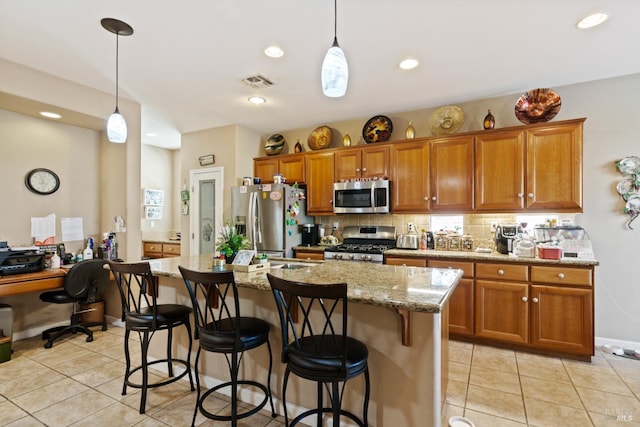 kitchen with a center island, light stone counters, hanging light fixtures, and appliances with stainless steel finishes