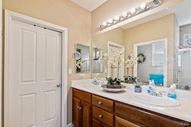 bathroom featuring double vanity, an enclosed shower, and a sink