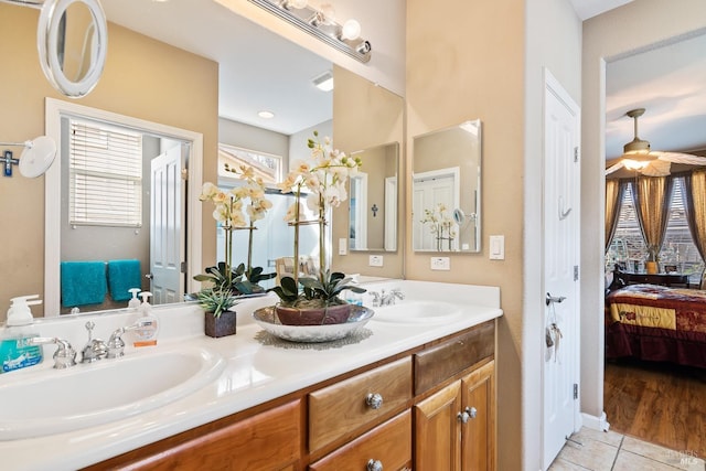 ensuite bathroom featuring tile patterned floors, double vanity, a sink, and ensuite bathroom