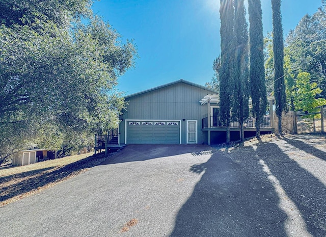 view of front of property featuring driveway, an attached garage, and fence