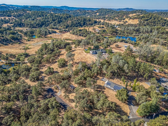 birds eye view of property featuring a mountain view and a wooded view