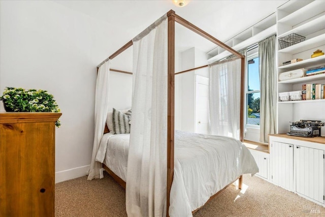 bedroom with baseboards and light colored carpet