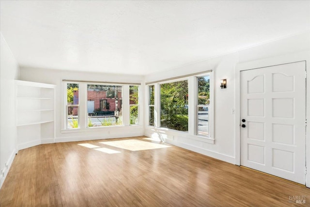 entrance foyer with baseboards and wood finished floors