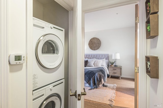 washroom featuring stacked washing maching and dryer and hardwood / wood-style floors