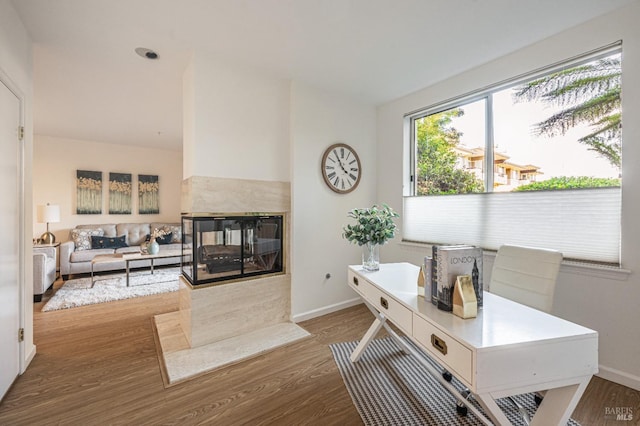 home office featuring dark wood-type flooring and a high end fireplace