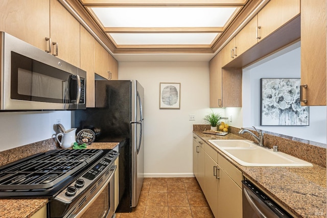 kitchen with light brown cabinets, appliances with stainless steel finishes, light tile patterned floors, and sink