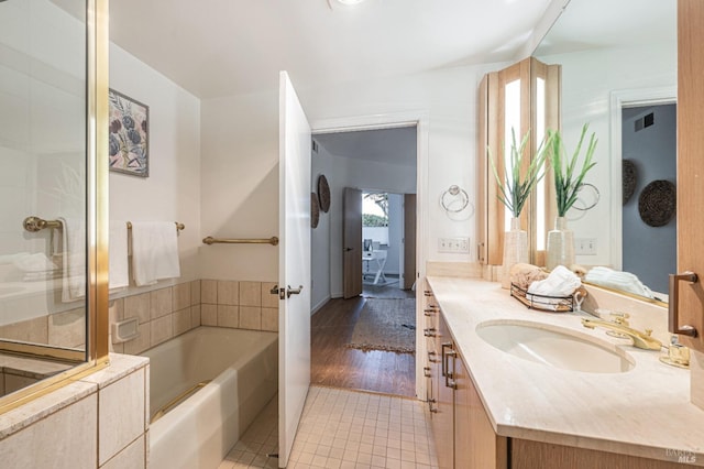 bathroom with vanity, a washtub, and hardwood / wood-style flooring