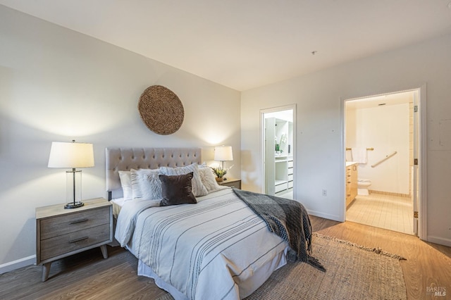 bedroom with connected bathroom and dark hardwood / wood-style flooring