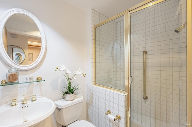 bathroom featuring sink, a shower with shower door, and toilet