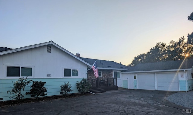 ranch-style home with a deck and a garage