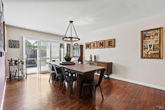 dining room featuring dark wood-type flooring and a chandelier