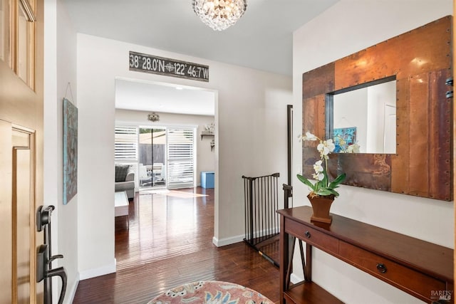 foyer entrance with dark hardwood / wood-style floors and an inviting chandelier