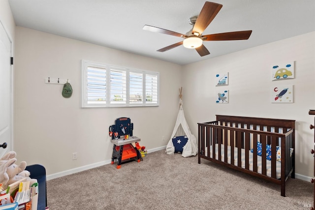 carpeted bedroom featuring ceiling fan and a crib