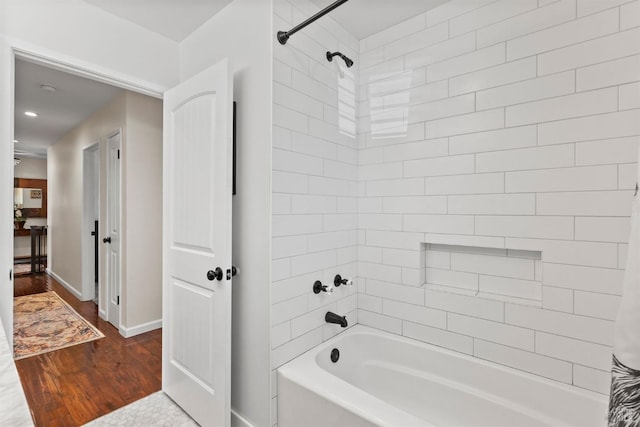 bathroom with hardwood / wood-style floors and shower / bath combination with curtain