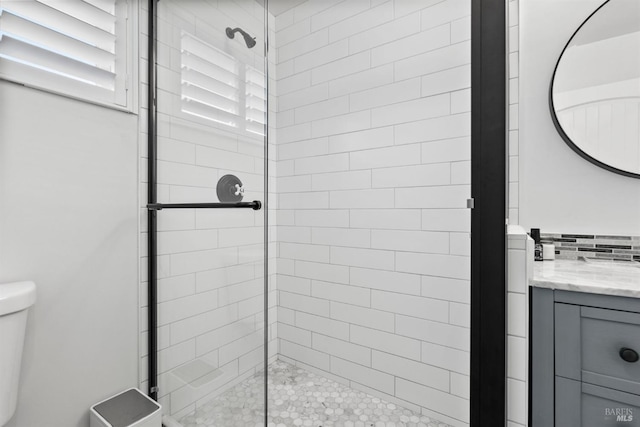 bathroom with vanity, toilet, and a shower with shower door