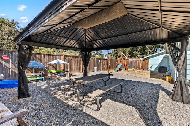 view of patio / terrace featuring a playground, central AC, and a gazebo