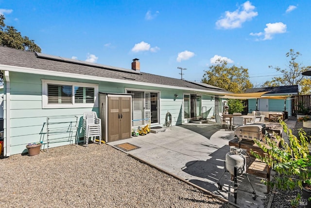 rear view of house featuring solar panels and a patio