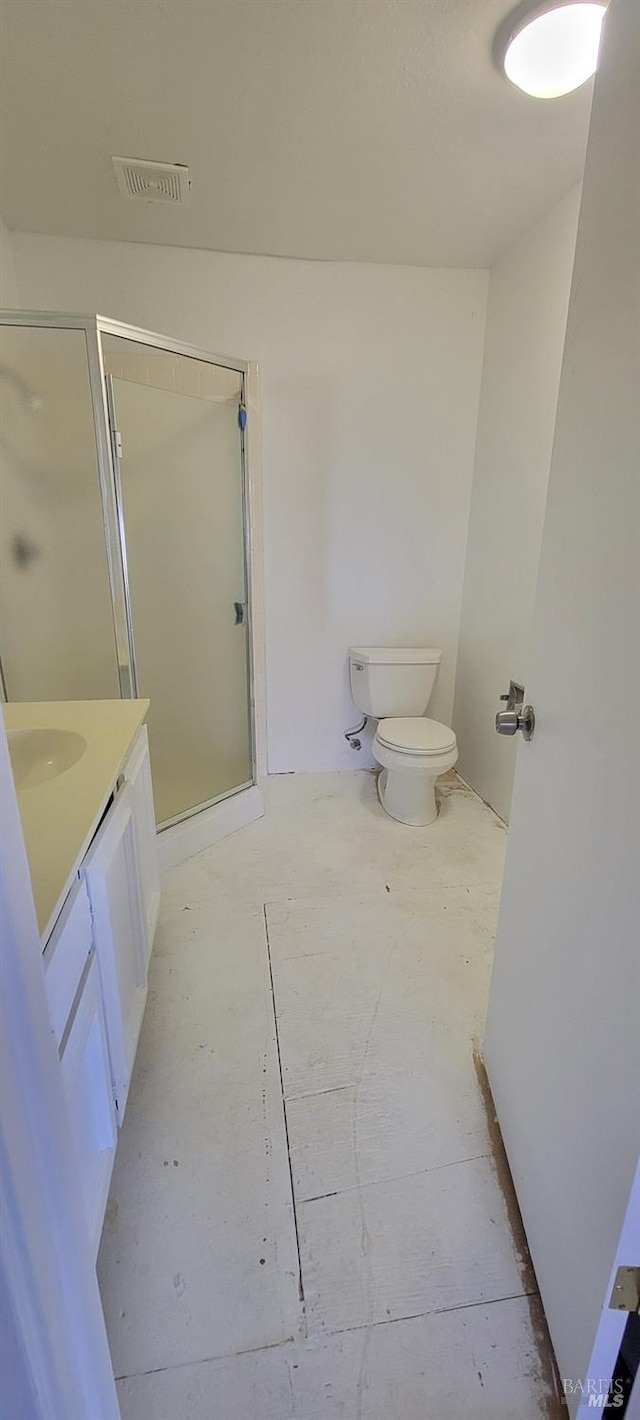 bathroom featuring vanity, toilet, and an enclosed shower