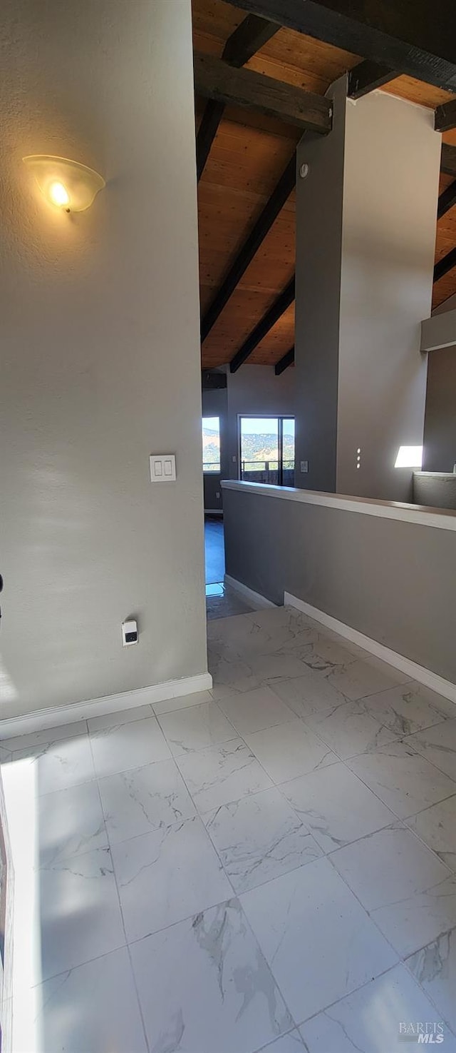 unfurnished room featuring lofted ceiling with beams and wooden ceiling