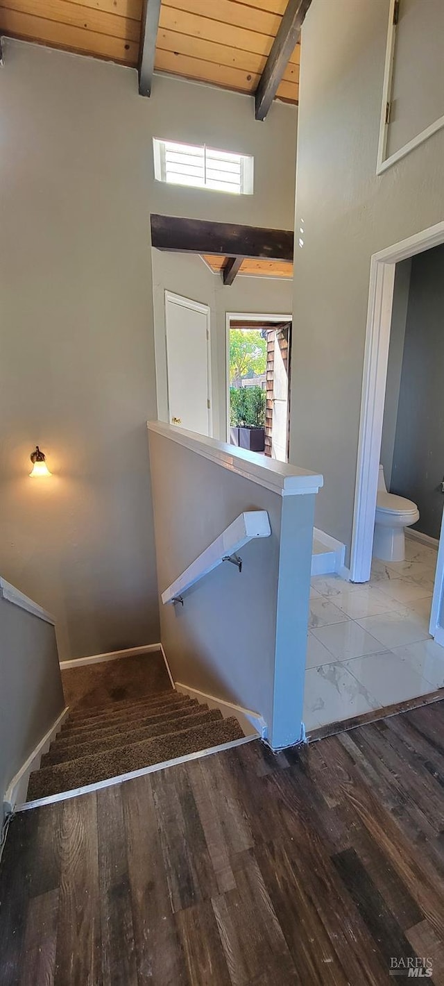 stairway with wood ceiling, wood-type flooring, vaulted ceiling with beams, and plenty of natural light