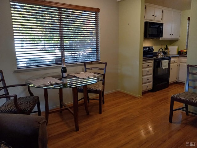 dining space with light wood-type flooring and baseboards