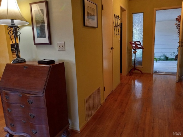 corridor featuring wood finished floors and visible vents