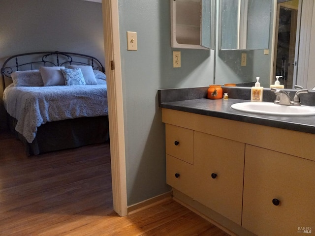 ensuite bathroom with wood finished floors, vanity, and connected bathroom