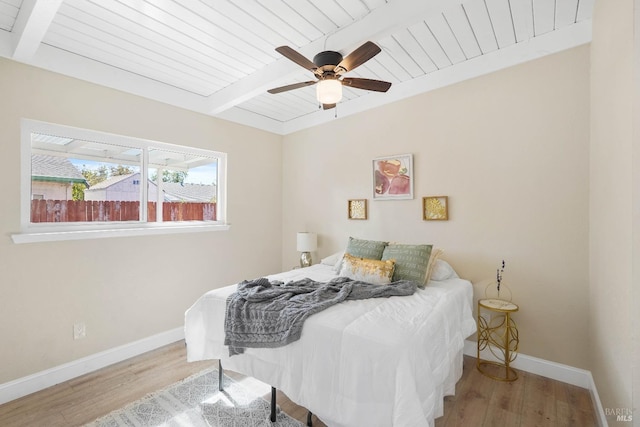 bedroom featuring light wood-type flooring, beam ceiling, and ceiling fan