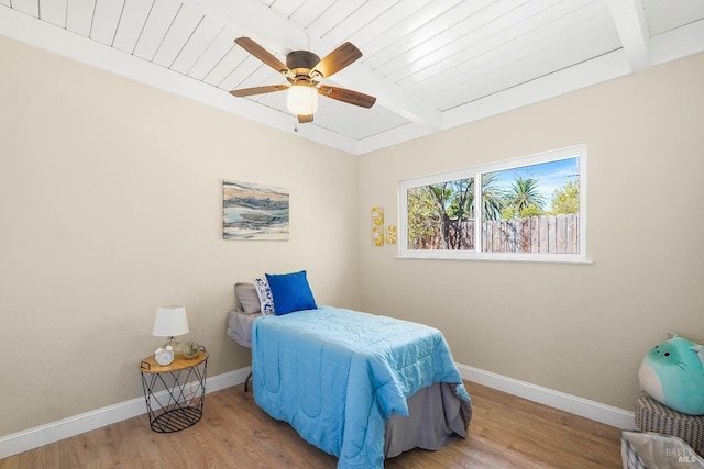 bedroom with wood ceiling, light wood-type flooring, ceiling fan, and beamed ceiling