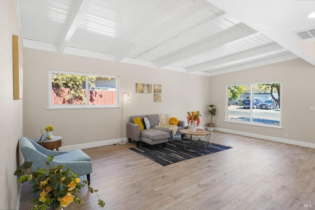 living room featuring light hardwood / wood-style flooring and vaulted ceiling with beams