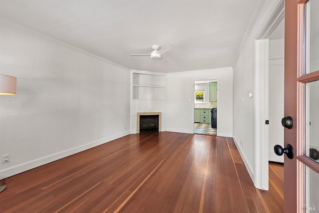 unfurnished living room with ornamental molding, ceiling fan, a tile fireplace, and dark hardwood / wood-style flooring