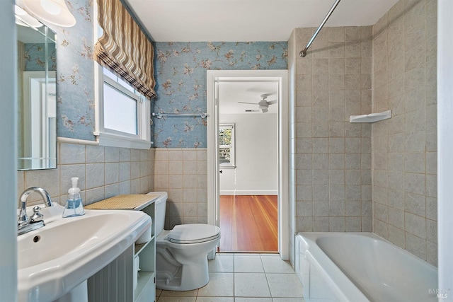 full bathroom featuring ceiling fan, tiled shower / bath, sink, tile patterned floors, and toilet