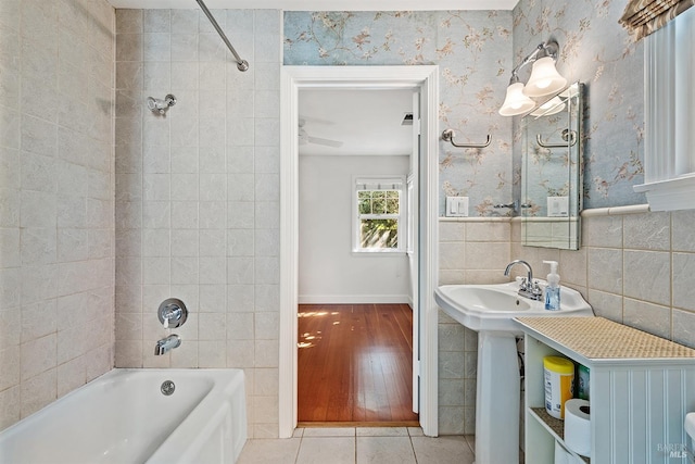 bathroom with tiled shower / bath, tile walls, and hardwood / wood-style floors