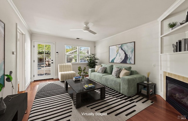 living room with wood-type flooring, crown molding, and ceiling fan