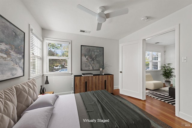 bedroom featuring wood-type flooring, multiple windows, and ceiling fan