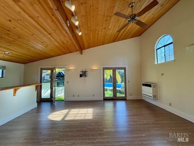 unfurnished living room with heating unit, lofted ceiling with beams, dark wood-type flooring, wooden ceiling, and french doors