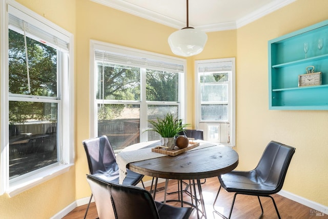 dining area featuring crown molding, wood finished floors, and baseboards