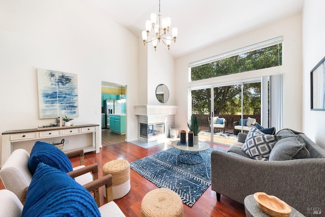 living area with wood finished floors, a multi sided fireplace, and high vaulted ceiling