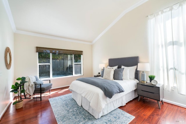 bedroom with dark wood finished floors, baseboards, crown molding, and lofted ceiling