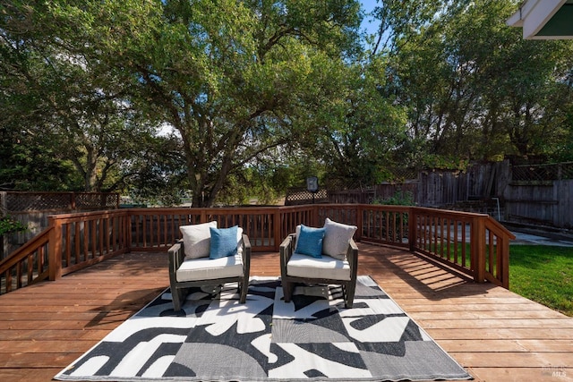 wooden deck with an outdoor living space and a fenced backyard