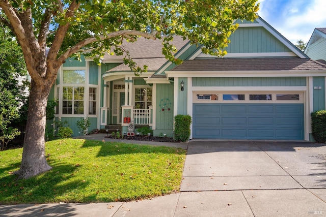 view of front of home with driveway, a shingled roof, an attached garage, and a front yard