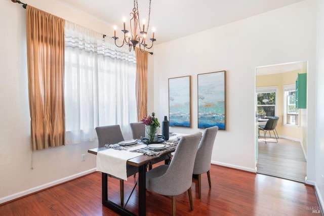 dining area with wood finished floors, baseboards, and a chandelier