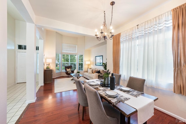 dining room featuring baseboards, a notable chandelier, and dark wood-style floors