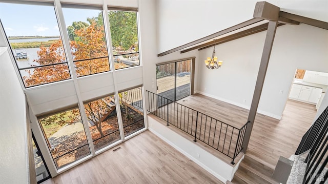 staircase featuring a towering ceiling, plenty of natural light, and hardwood / wood-style floors